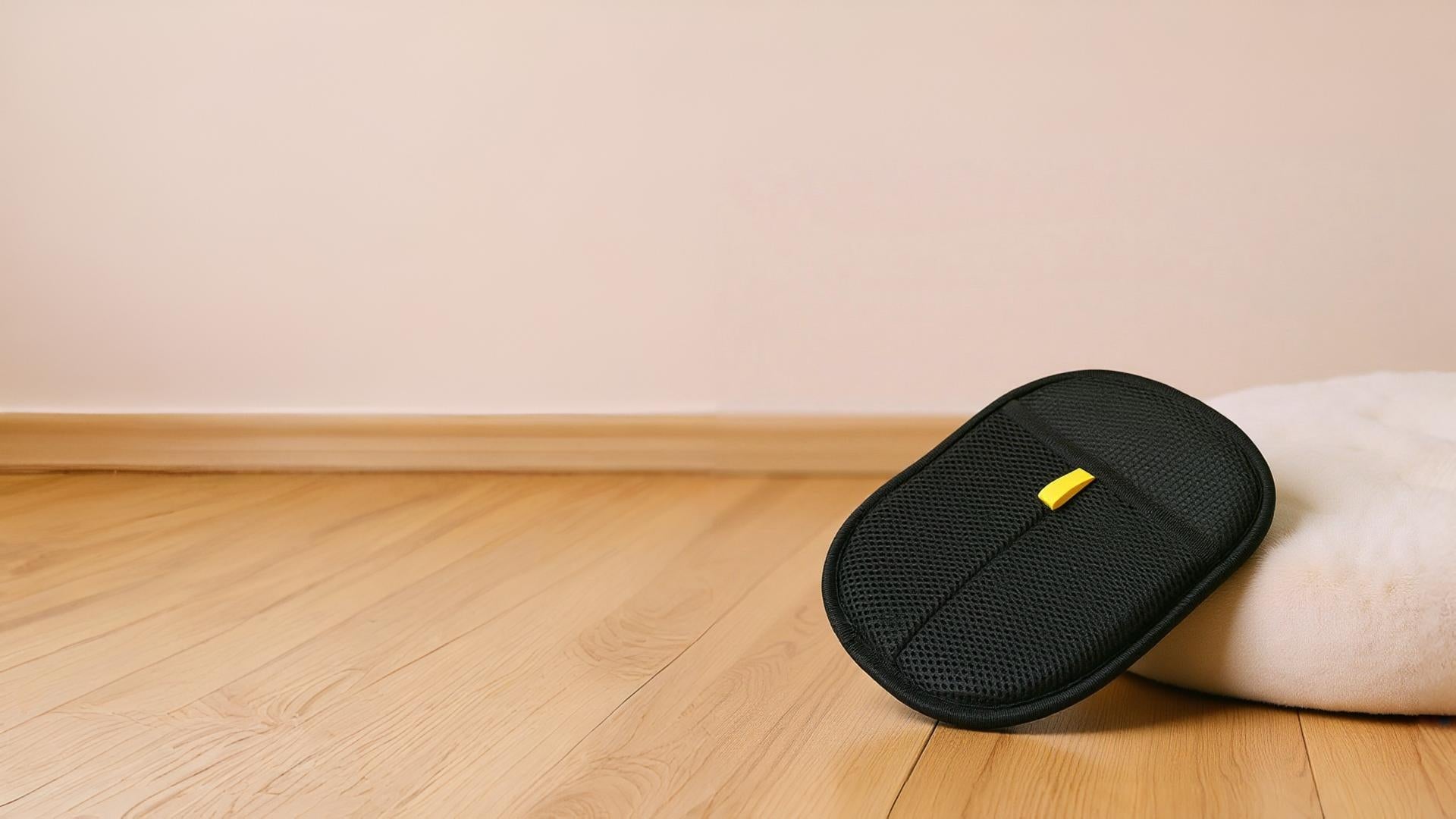 Black carrying case with a yellow tag on a wooden floor